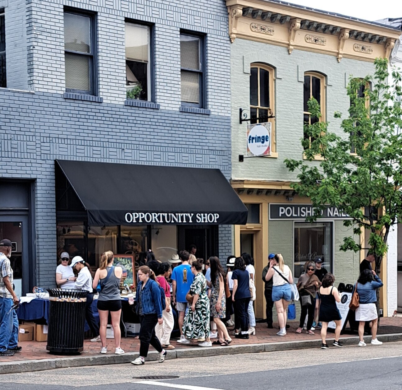 Christ Child Opportunity Store customers looking over sidewalk sale items during Georgetown French Market.