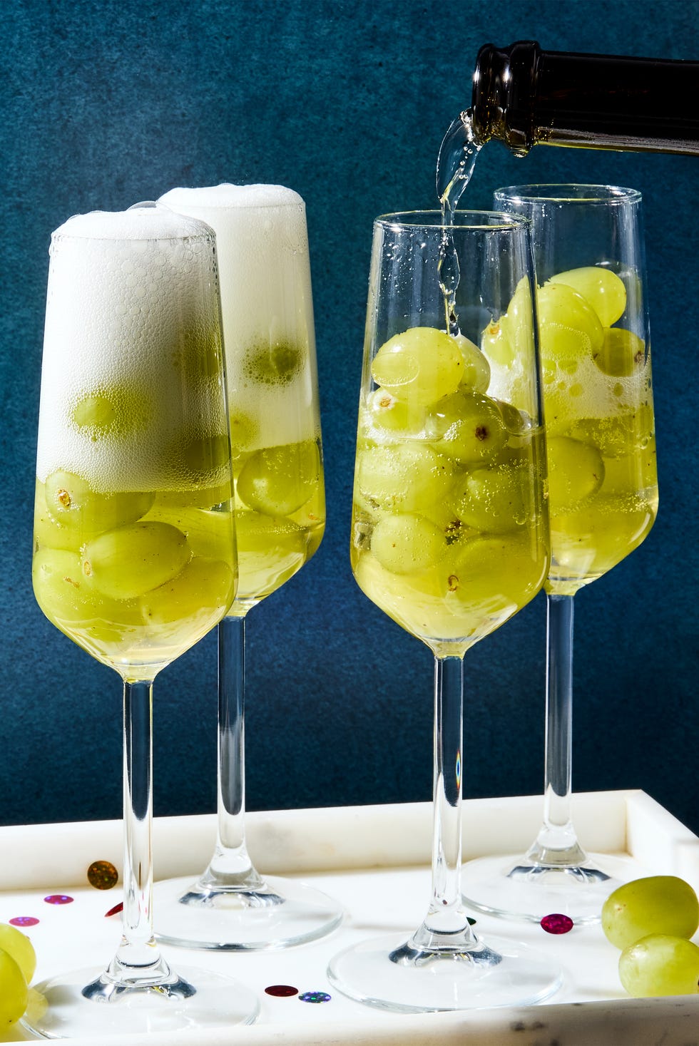 glasses of champagne filled with 12 green grapes