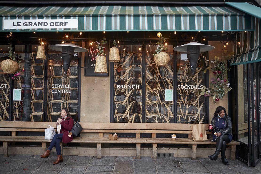 People eat their lunch outside a closed restaurant on February 1 in Paris.