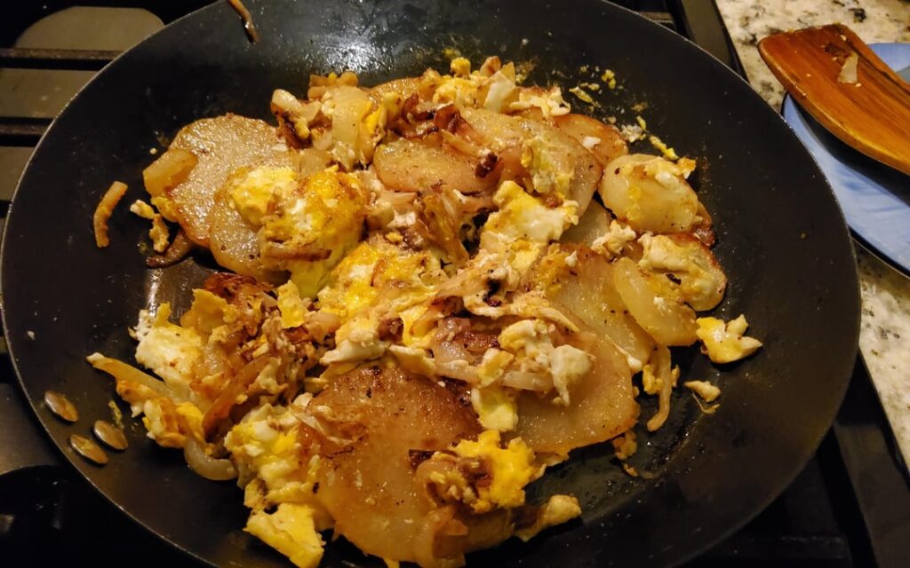 My Mom made something like this growing up, fry sliced potatoes and onions till done and crack some eggs to make a poor man's meal.