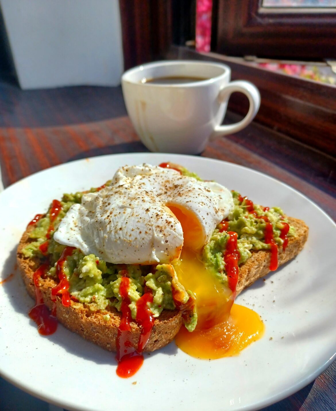 [OC] Made avocado toast with a drizzle of hot sriracha and a poached egg for a healthy breakfast this morning