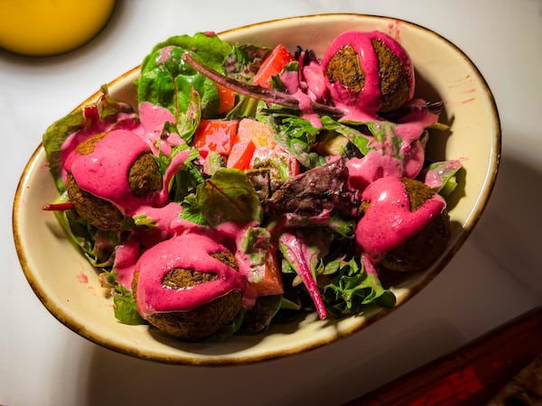 The falafel salad at Banu Mediterranean Grill was tough and dry, and the weirdly pink dressing was much too sweet. (Henri Hollis/henri.hollis@ajc.com)