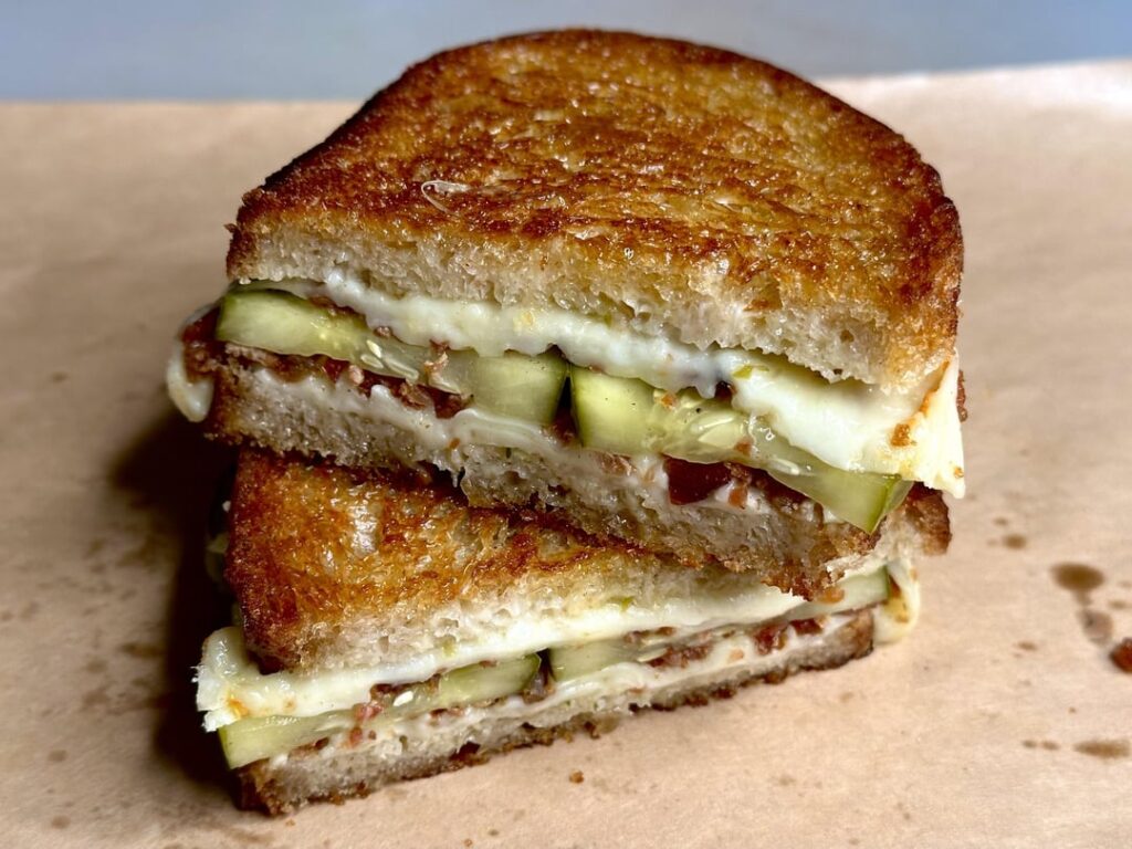Sweet and spicy pickle melt with crumbled bacon bits on homemade bread