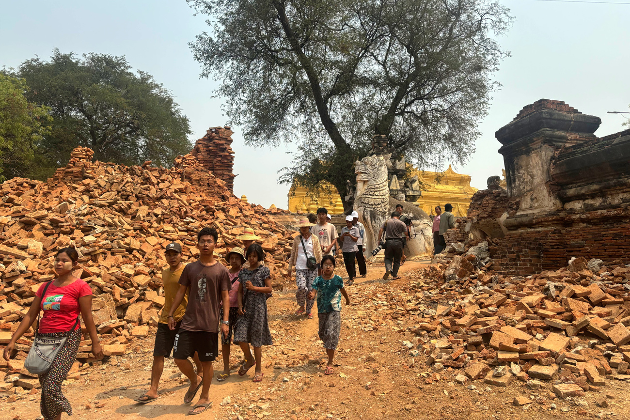 Photo of people walking among rubble