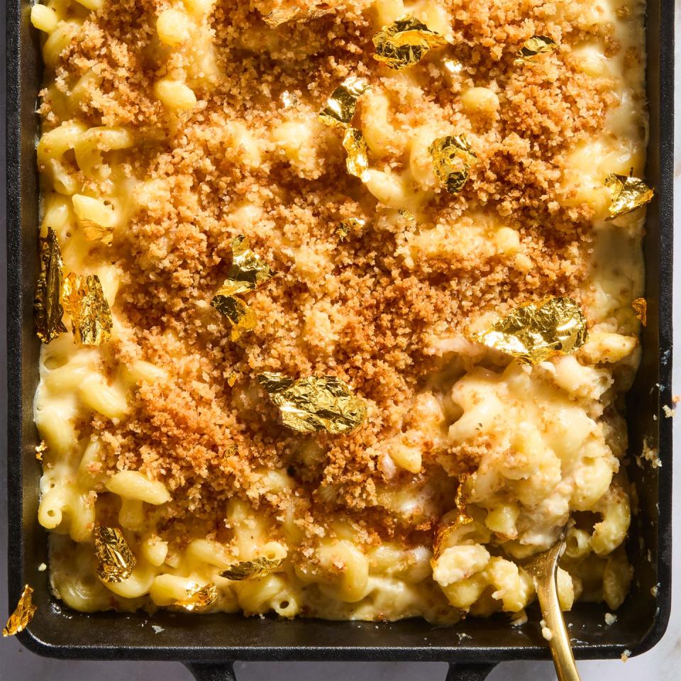 million dollar mac and cheese topped with panko breadcrumbs and gold leaf in a cast iron pan