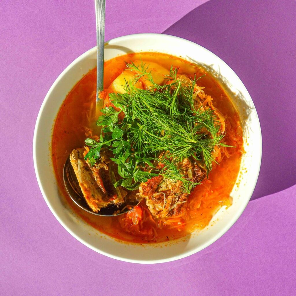 Kapuśniak - a recipe for Polish soup made with sauerkraut, pork ribs, and potatoes, topped with plenty of dill and parsley