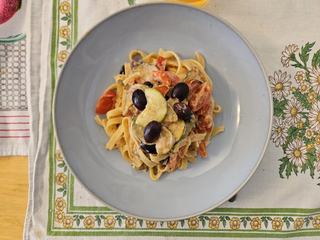 Tagliatelle with cherry tomatoes, zucchini, black olives and ricotta