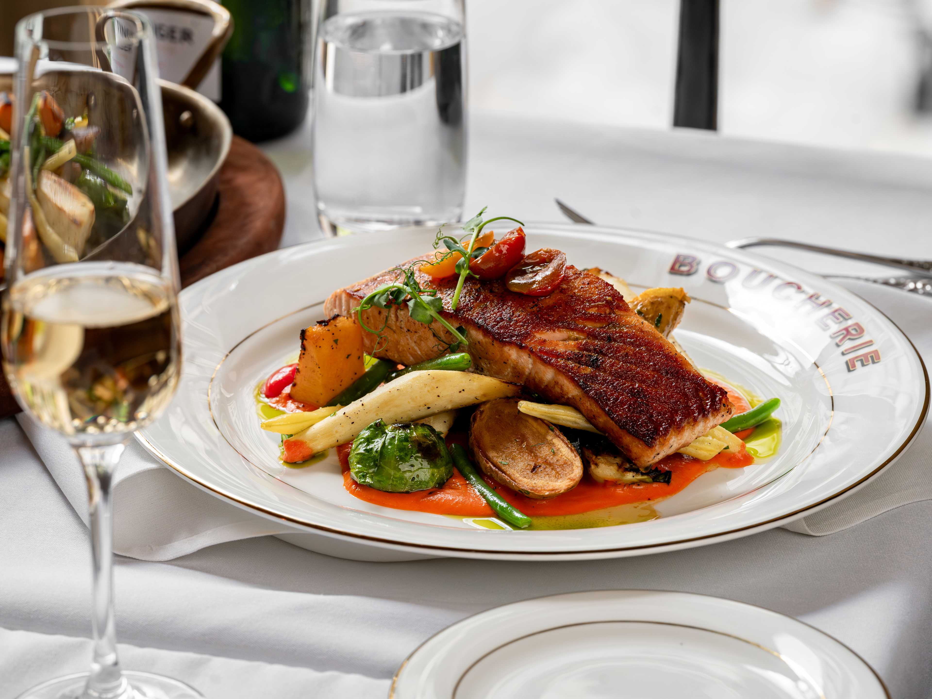 Roasted salmon on a pile of vegetables.