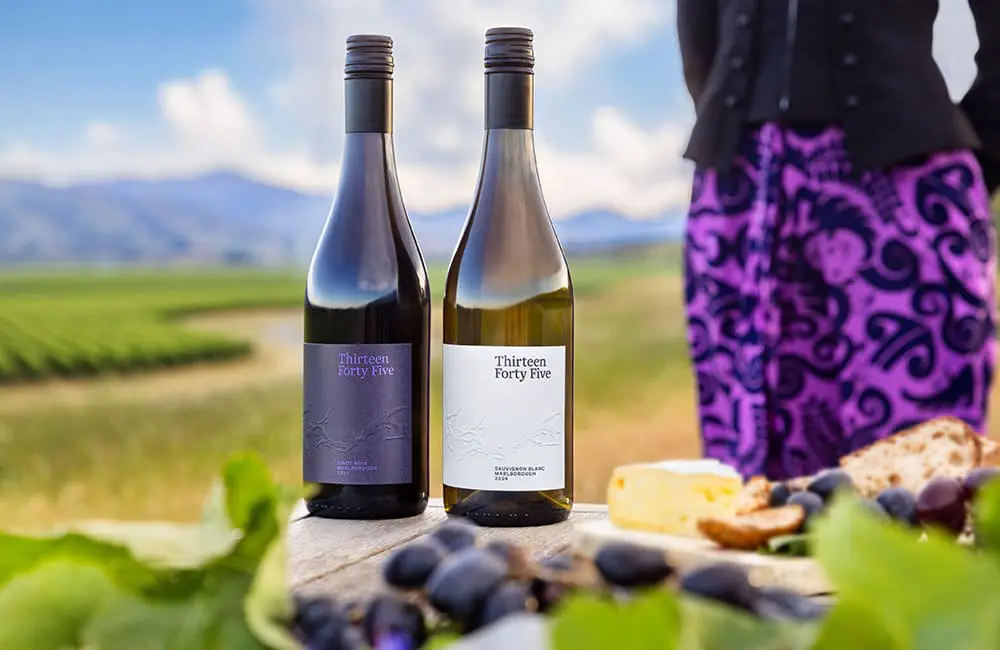 Air New Zealand's Thirteen Forty Five wine bottles with female flight attendant and Marlborough region in background.