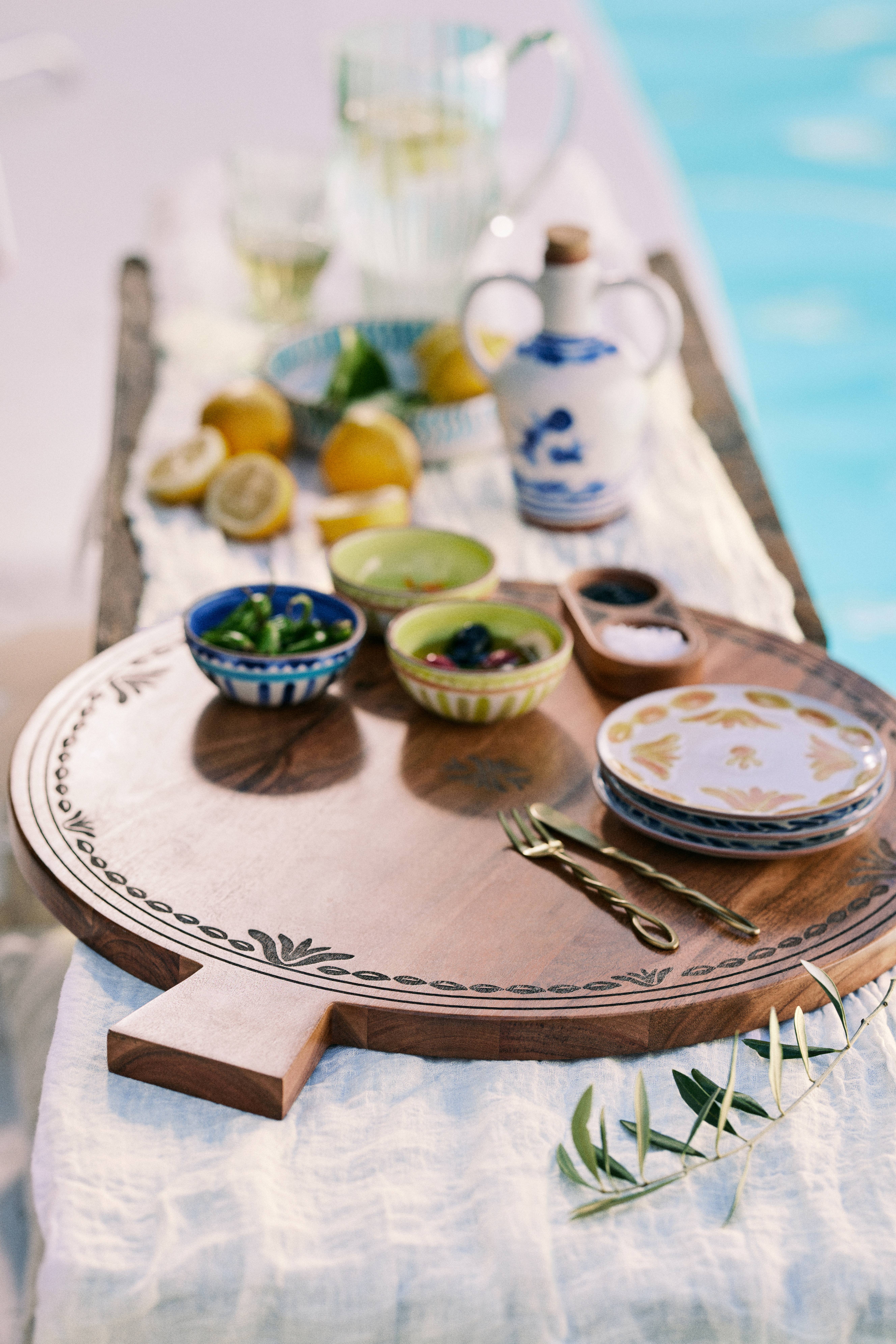 Tablescape featuring erving bowls, twisted flatware, and a sculptural olive oil vessel from the new Anthropologie x The Mediterranean Dish collaboration