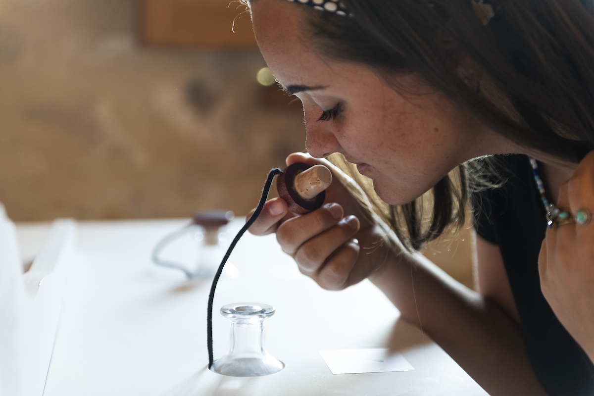 Woman sniffing bottle cork at sensory workshop
