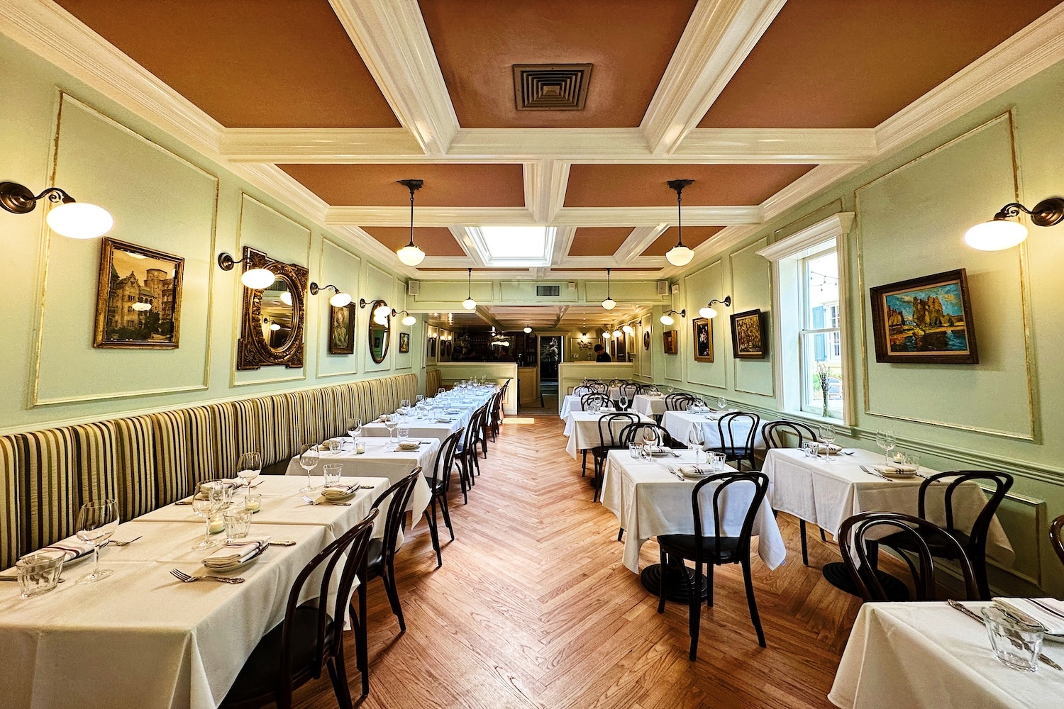 tables with chairs, green walls, lights on ceiling