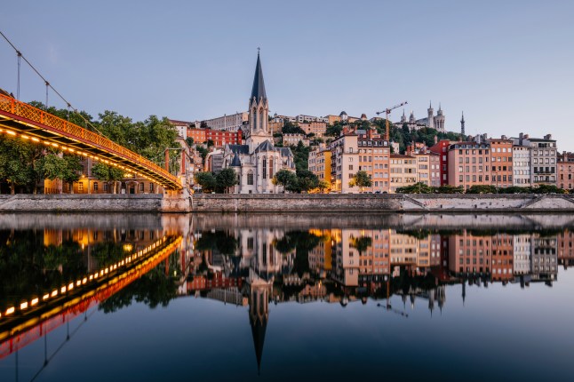 Paul-Couturier Footbridge over Saone river against buildings in city during sunset