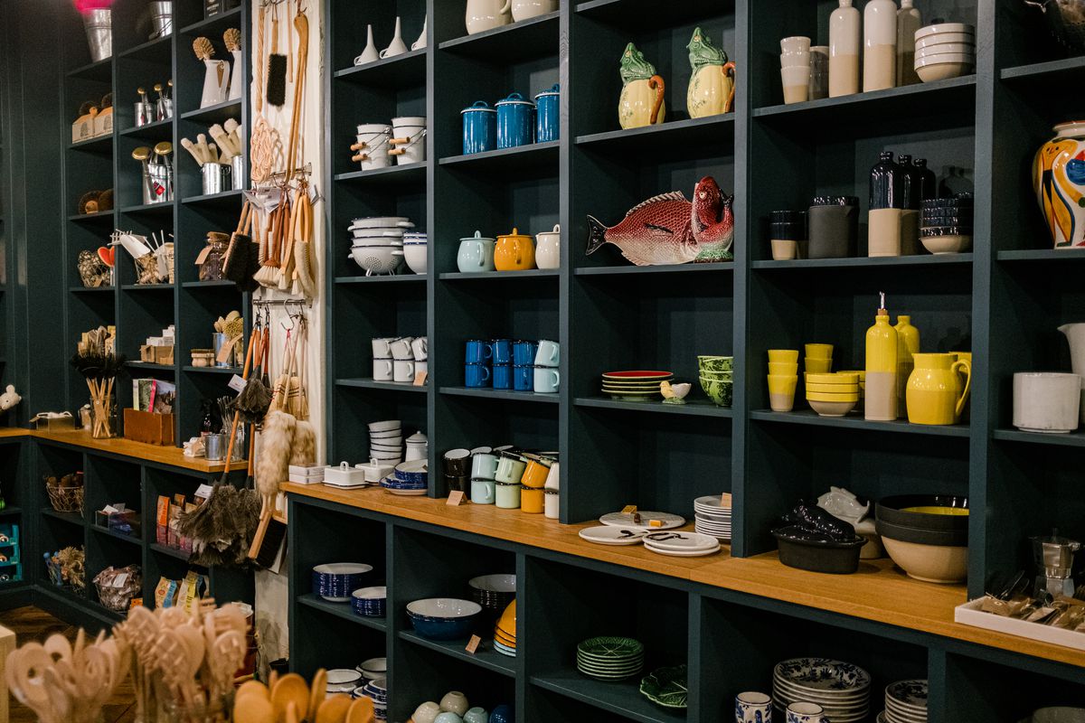 Dark green shelves filled with various kitchen ware.