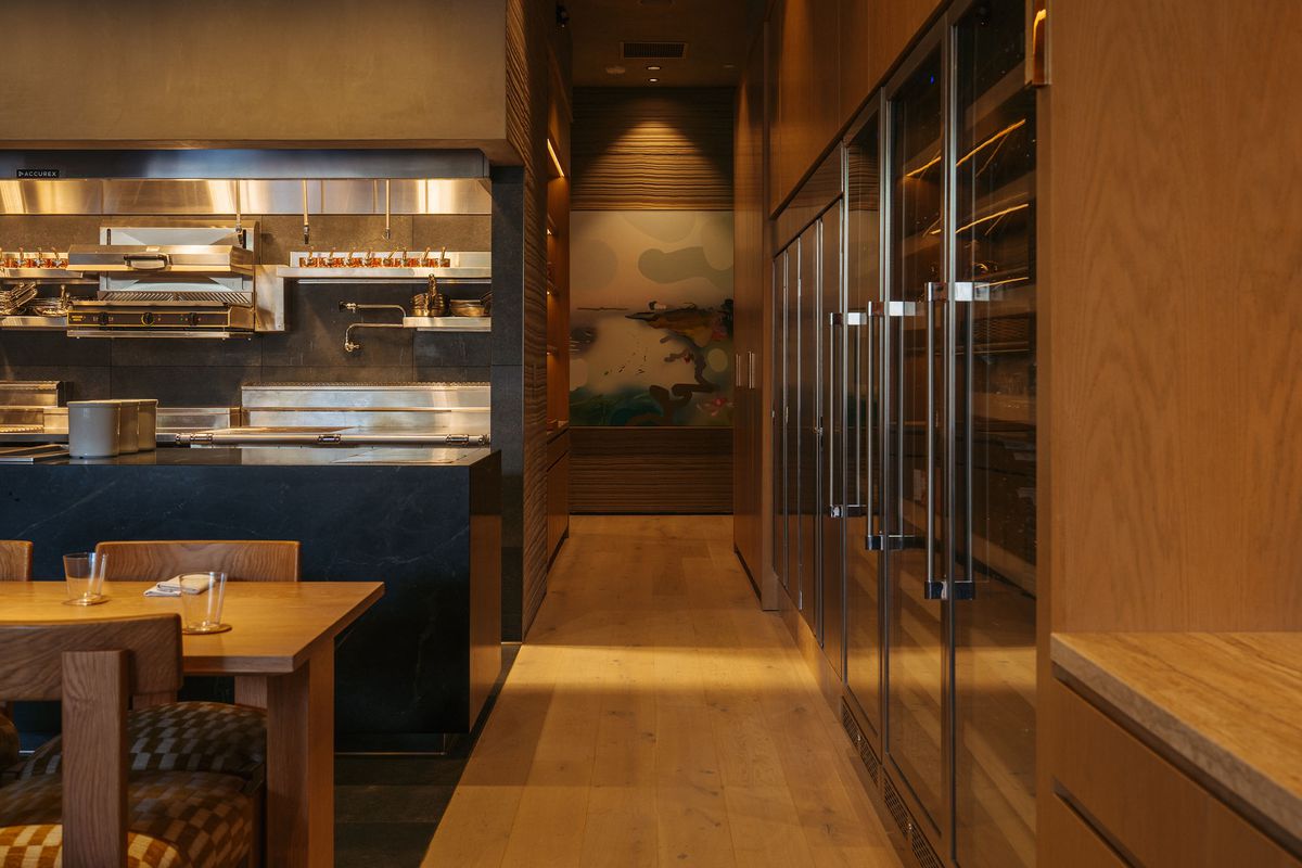 A hallway with kitchen and fridges.