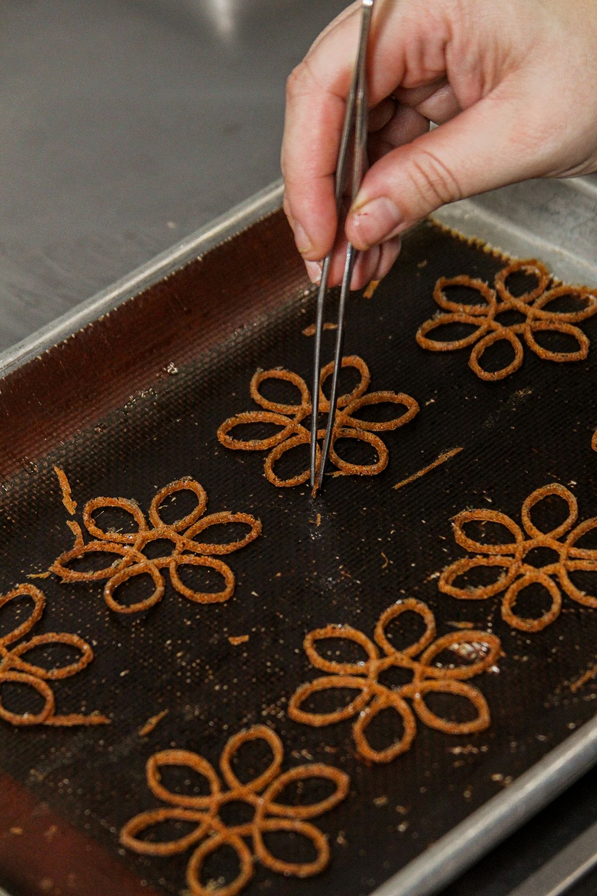 Delicate garnishes are picked up with tweezers