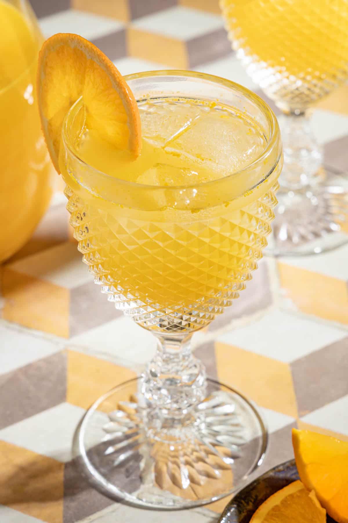 one glass of agua de valencia garnished with an orange slice.