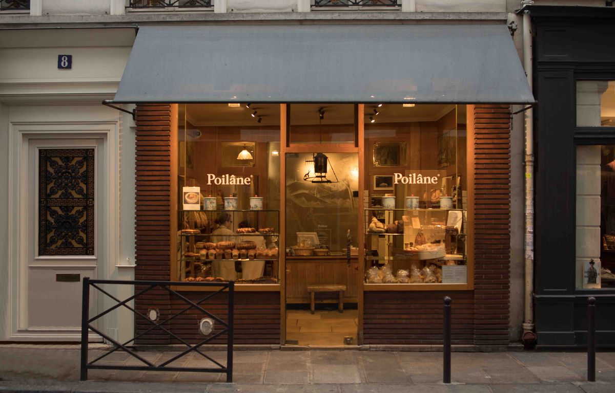 A bakery storefront warmly lit at dusk.