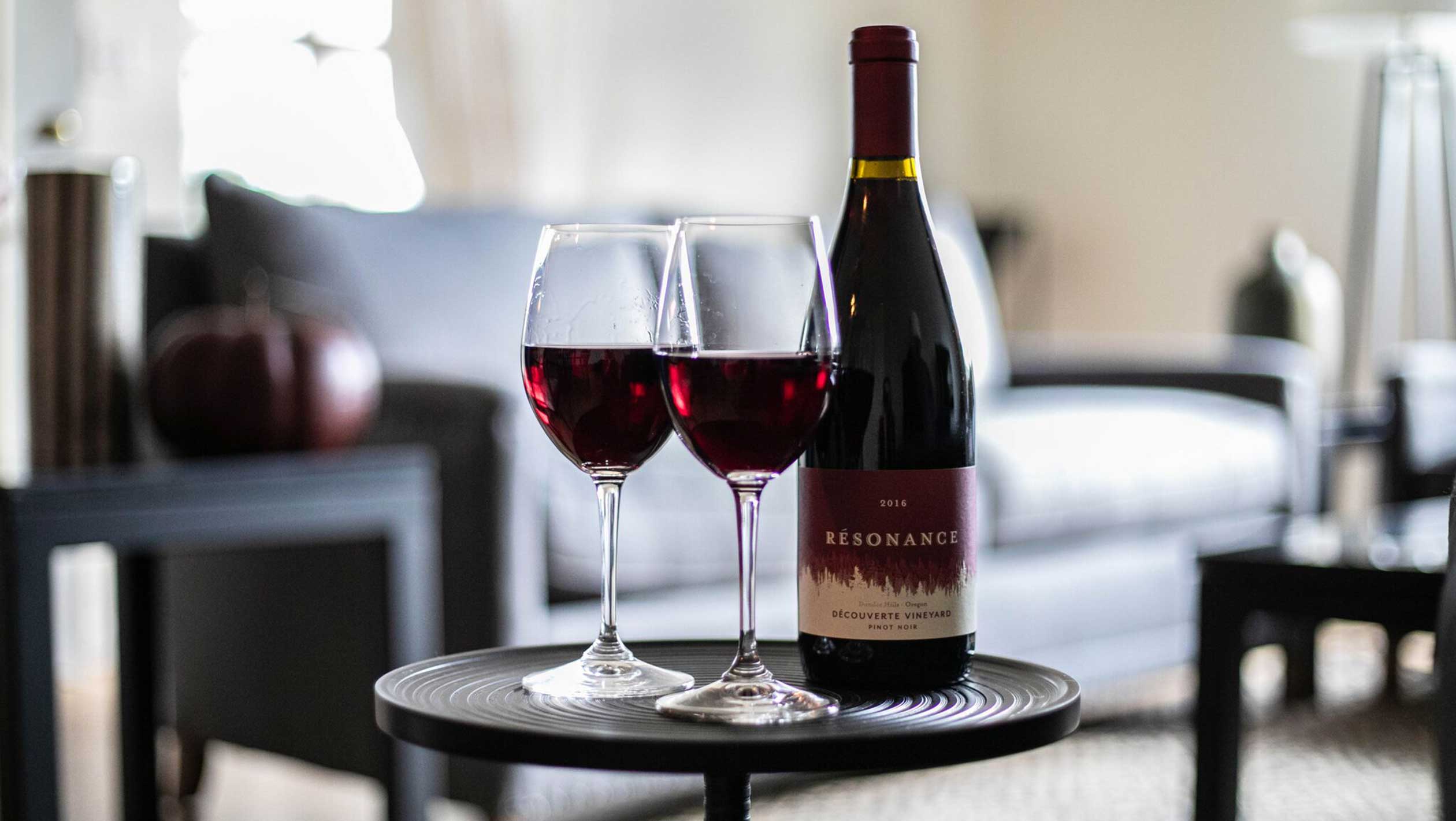 A bottle of Résonance next to two glasses of wine