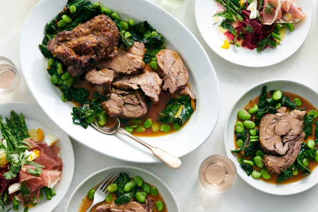 lamb with fava beans and greens on a white platter