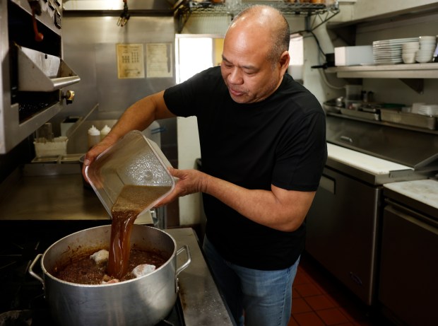 Libiran adds beef stock. (K.C. Alfred / The San Diego...