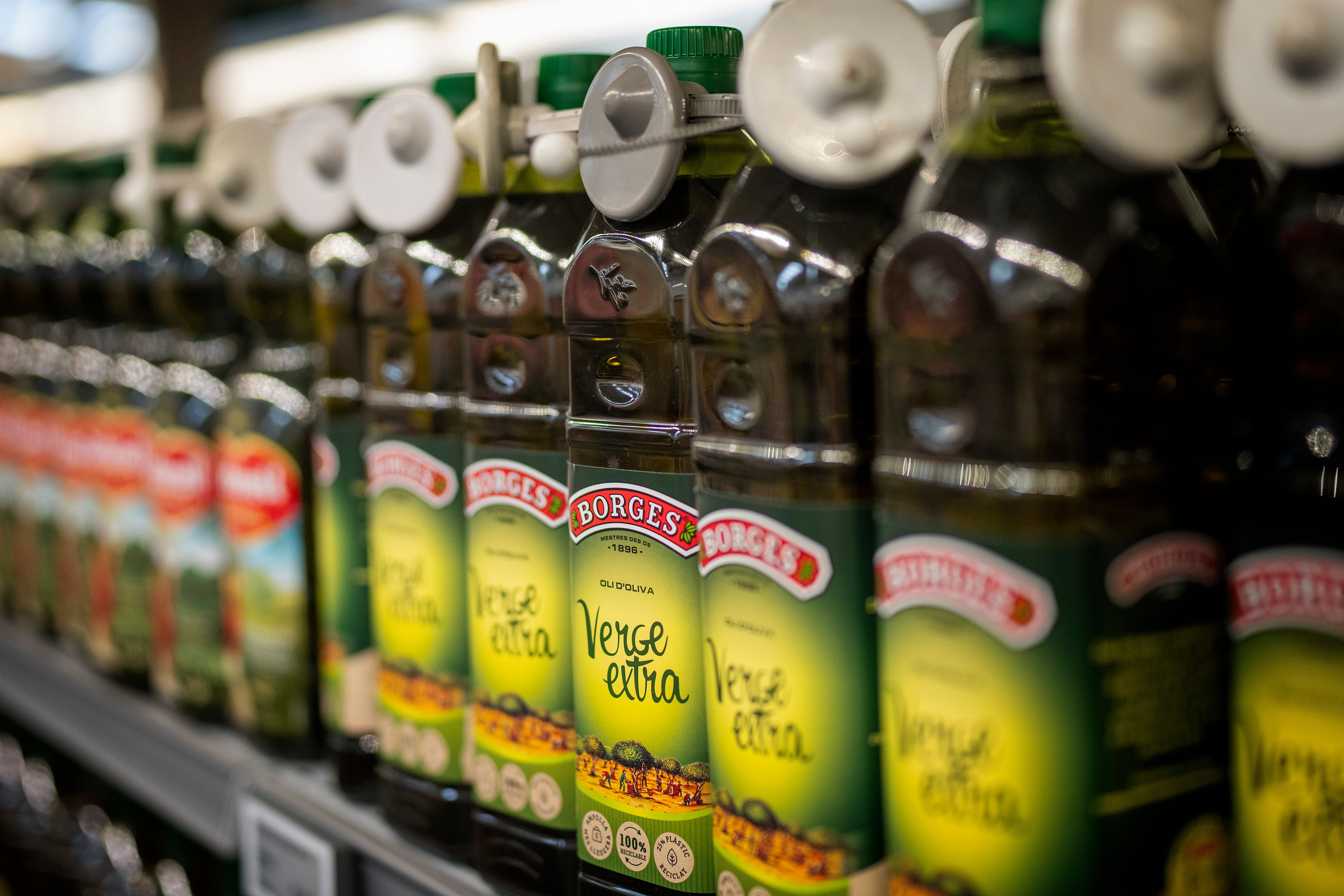 Bottles of virgin olive oil, sealed with an anti-theft system, are photographed on a shelf in a shop in Barcelona
