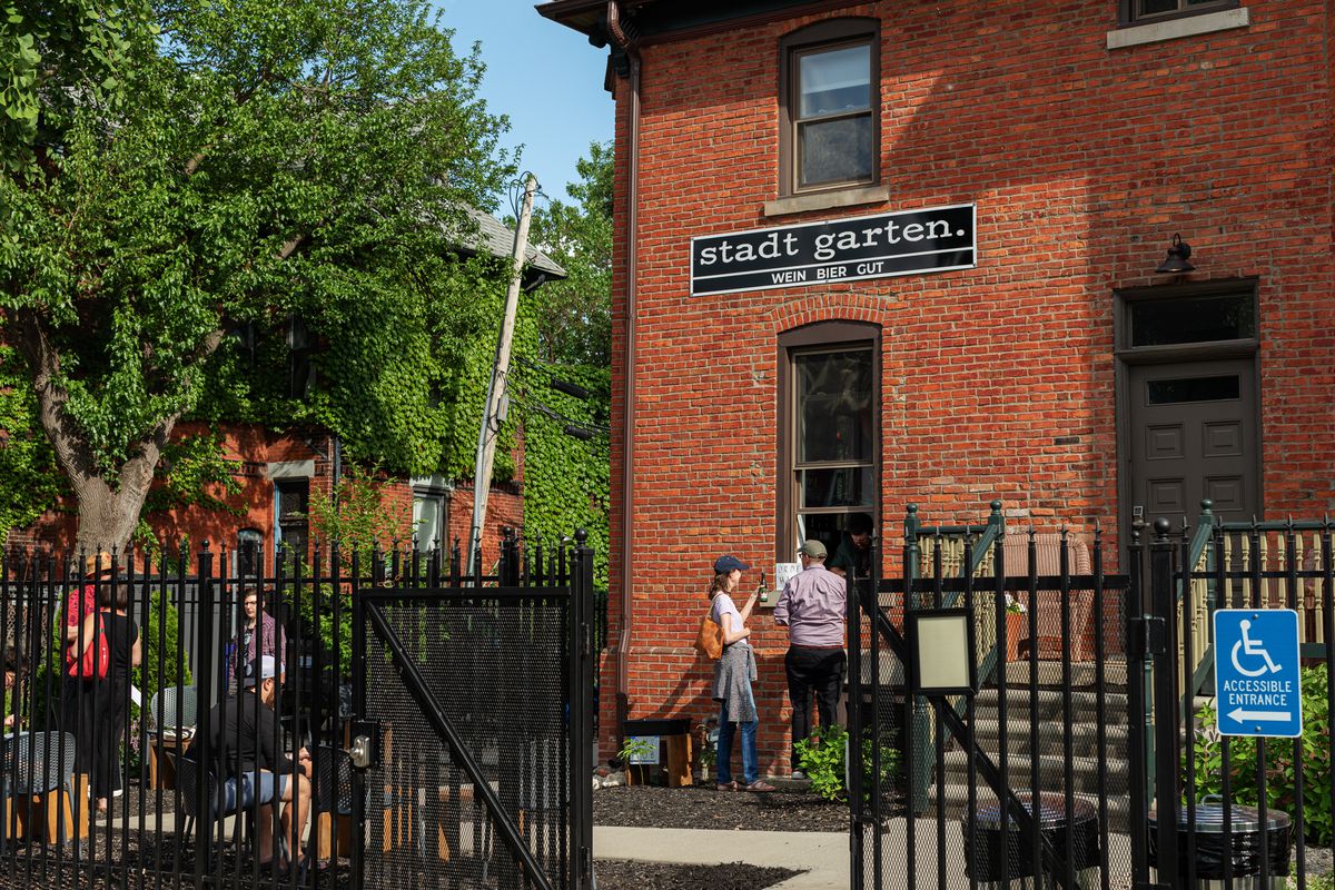 People gathering and placing orders at a walk up window at Stadt Garten in Midtown Detroit.