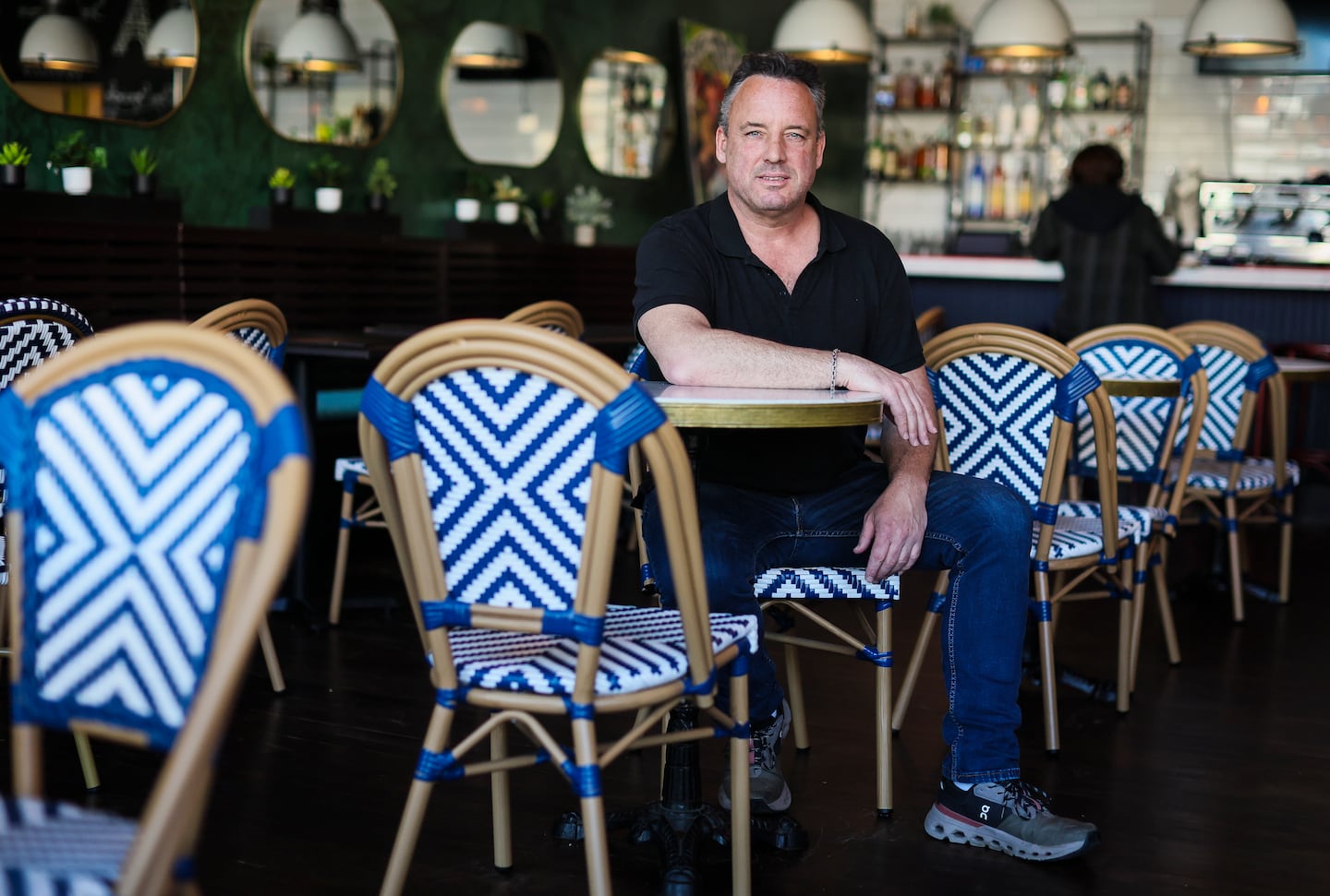 Restaurateur Loic Le Garrec sits at a table in his new Somerville restaurant, Café Saint-Germain.