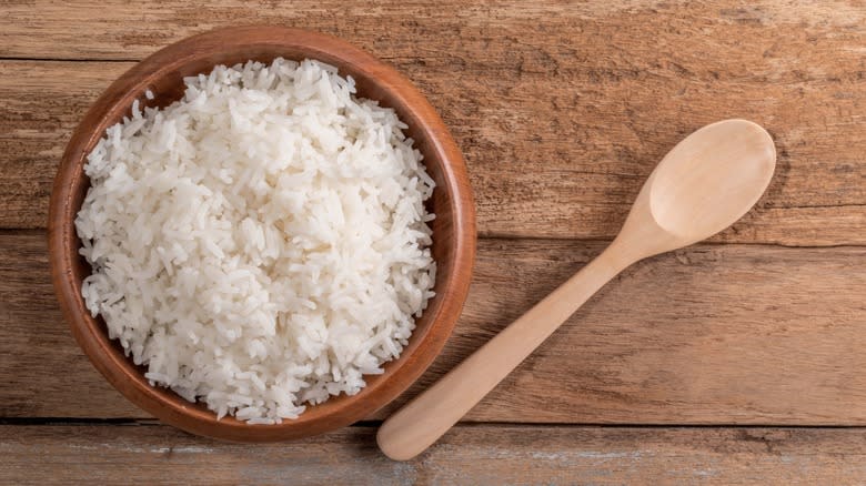 A bowl of basmati rice with a wooden spoon
