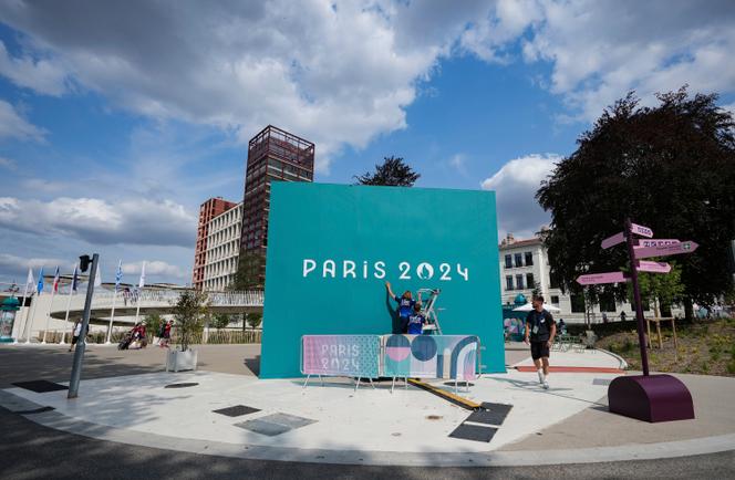 Volunteers fix a sign in the Olympic Village in Paris, France on Wednesday, July 24, 2024.
