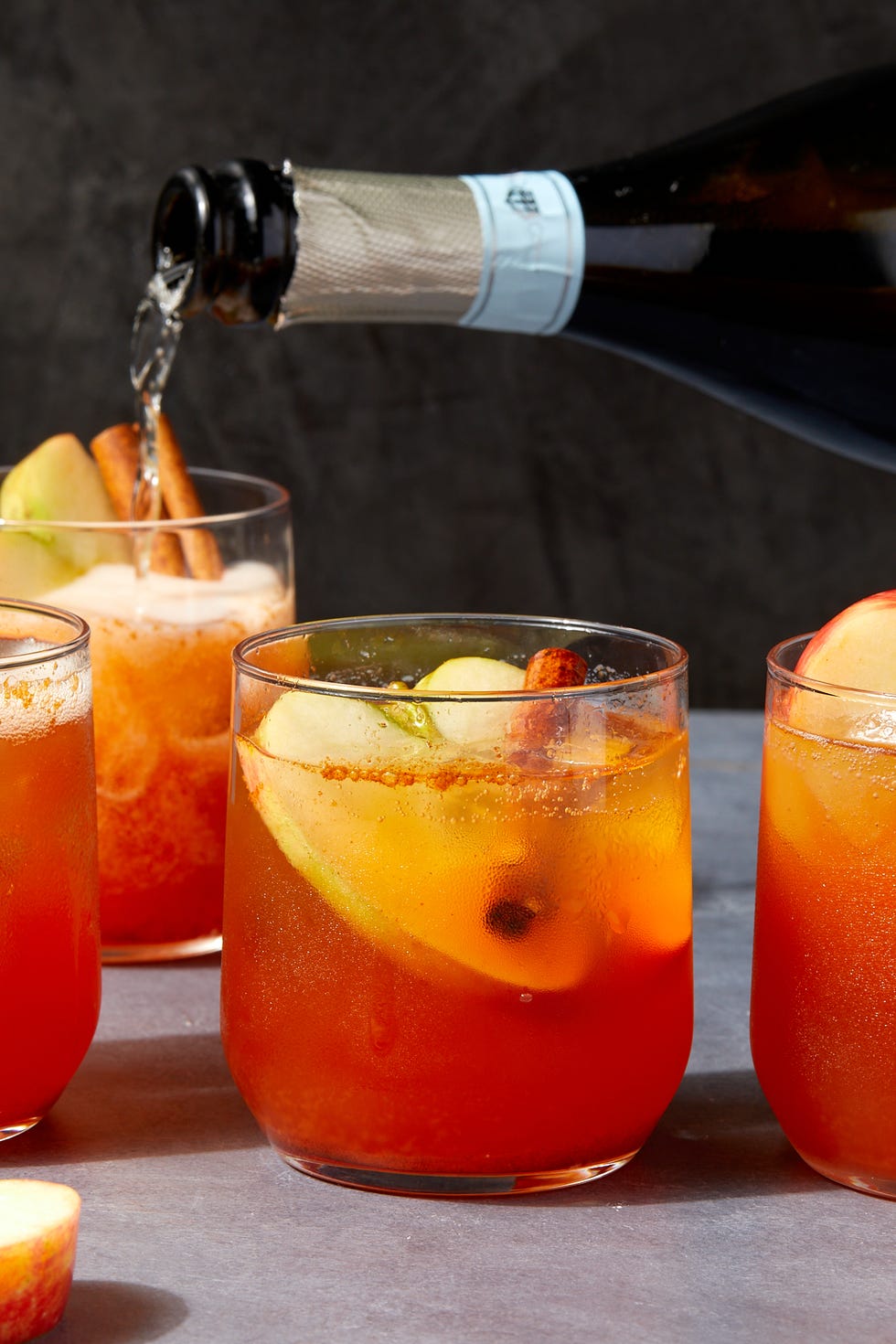 apple cider spritzes garnished with apples and cinnamon sticks