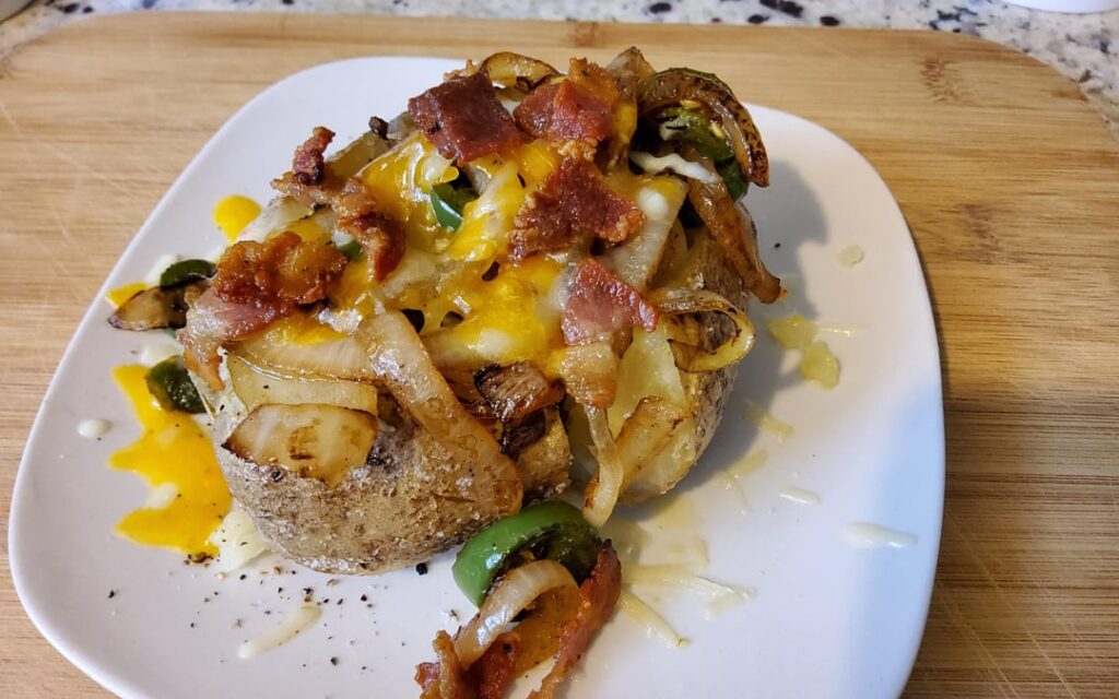 A perfect meal for one. Loaded baked potato with onions and jalapeños cooked in bacon fat.