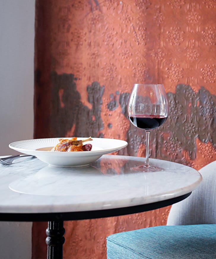 A French dish and red wine on a table