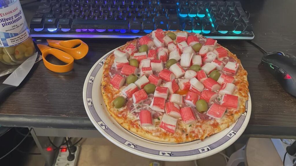 frozen pizza with imitation crab and whole green olives.