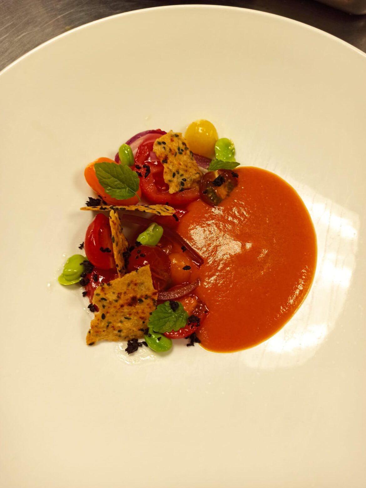 Vegan spiced tomato bloody Mary gazpacho,lemon skin gel, heirloom cherry tomatoes and, fresh broad beans