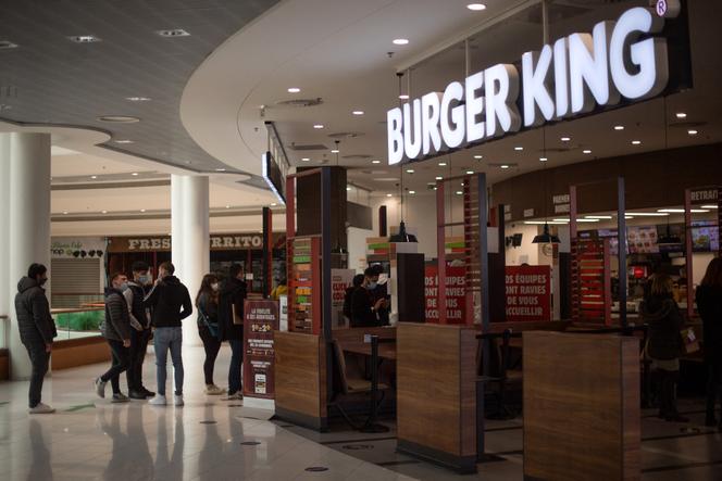 People queue at the fast food chain in a Burger King in a shopping mall, on January 13, 2021 in Saint-Herblain, outside of the city of Nantes. (Photo by LOIC VENANCE / AFP)