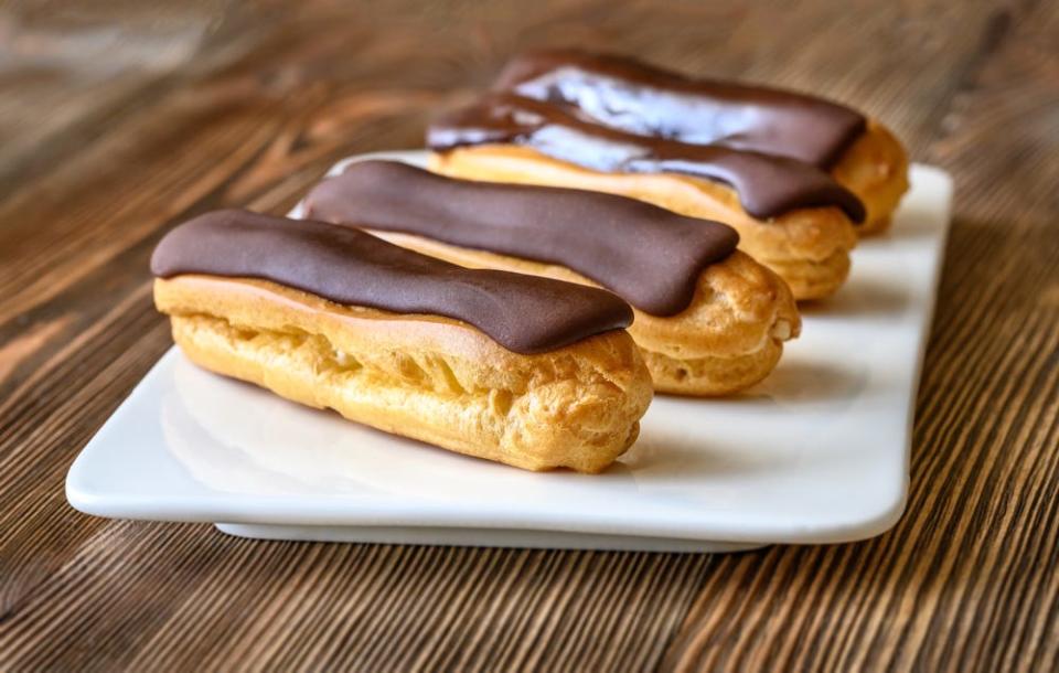 Eclairs with chocolate topping on serving plate