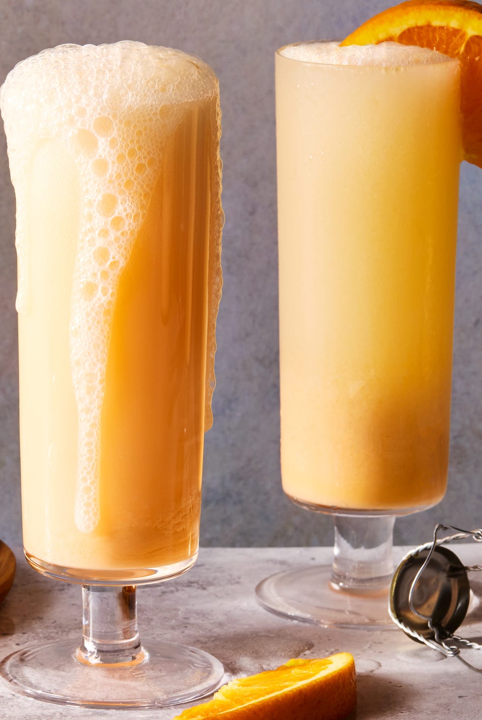 creamsicle mimosas filled with ice and garnished with an orange wedge