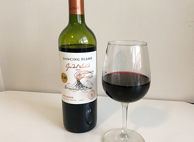 a bottle of red wine next to a glass of red wine