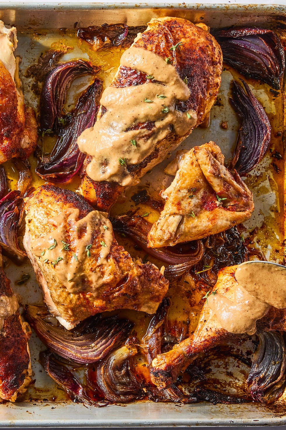 paprika dusted chicken roasted on a bed of herby sliced red onions and whole garlic cloves then topped with an umami rich, spoonable sauce made from chicken fat roasted, charred onions, butter, sweet white vinegar, and crushed red pepper