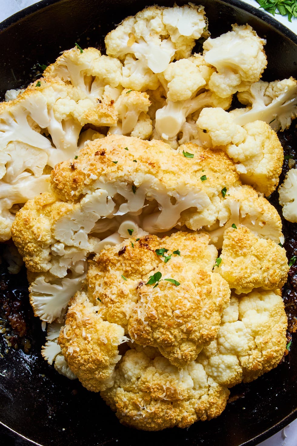 whole roasted cauliflower sliced in a cast iron skillet