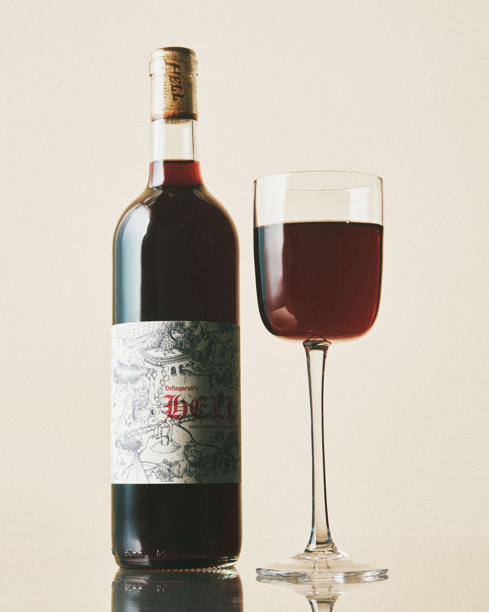 A glass and bottle of Delinquente Hell Nero d'Avola