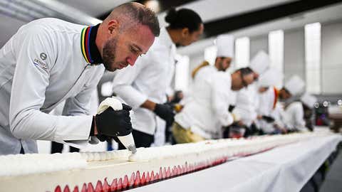 Pastry chefs work on the world's largest strawberry cake, 121,88m long during a Guinness World Record event in Argenteuil, northern suburb of Paris, on April 23, 2025. Some 350 kilos of strawberries, 150 kilos of sugar, 415 kilos of creme patissiere and 4,000 eggs: on April 23, 2025, pastry chef and owner of pastry shop La Maison Heloise, Youssef El Gatou broke the record for the world's largest strawberry cake, with a cake certified to be 121.88 metres long. (Photo by Julie SEBADELHA / AFP) (Photo by JULIE SEBADELHA/AFP via Getty Images)          