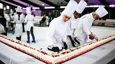 Pastry chefs work on the world's largest strawberry cake, 121,88m long during a Guinness World Record event in Argenteuil, northern suburb of Paris, on April 23, 2025. Some 350 kilos of strawberries, 150 kilos of sugar, 415 kilos of creme patissiere and 4,000 eggs: on April 23, 2025, pastry chef and owner of pastry shop La Maison Heloise, Youssef El Gatou broke the record for the world's largest strawberry cake, with a cake certified to be 121.88 metres long. (Photo by Julie SEBADELHA / AFP) (Photo by JULIE SEBADELHA/AFP via Getty Images)          