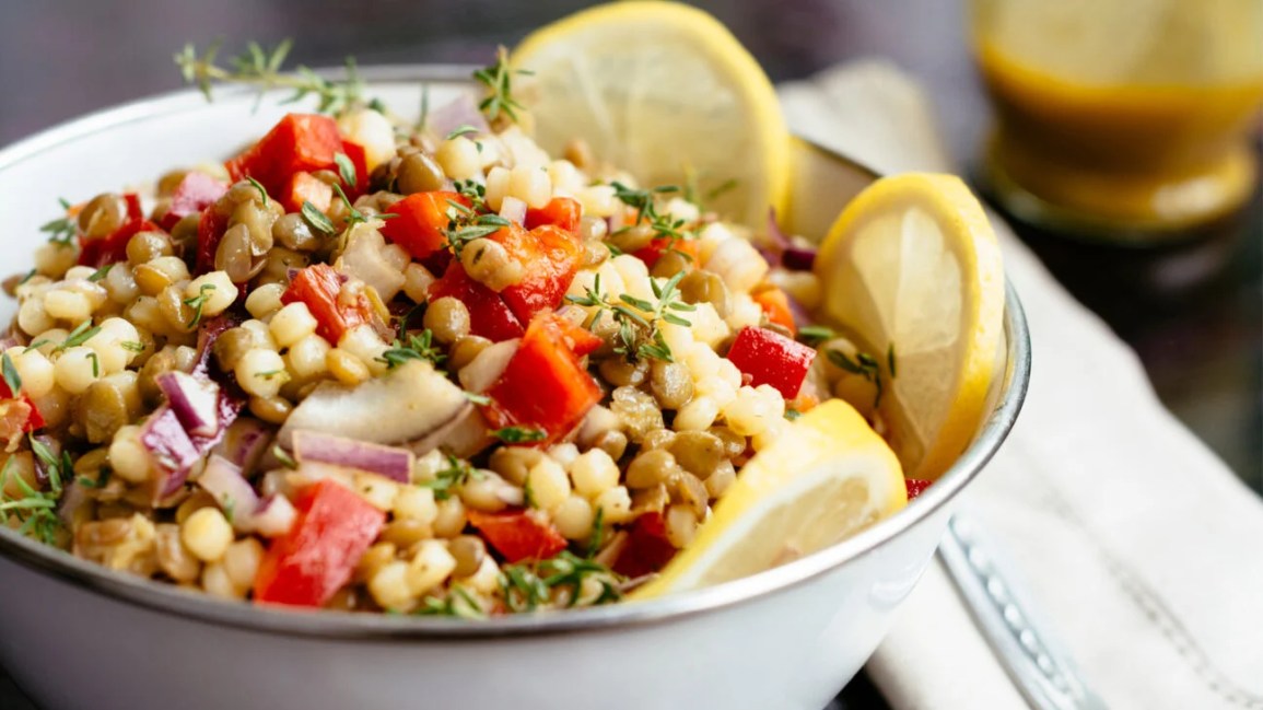 A bowl of veggies and grains on a table
