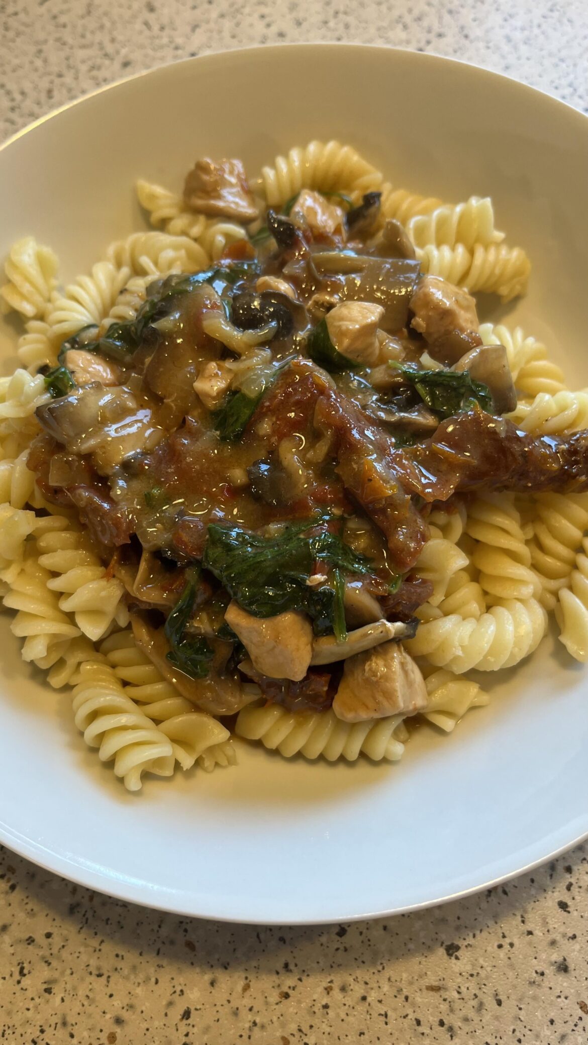 Chicken with sundried tomatoes, mushrooms and spinach in a creamy sauce served with paste