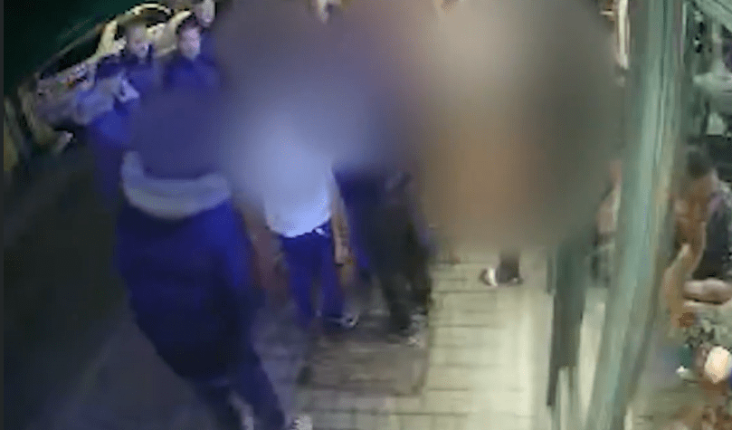 Blurry security camera footage of a group of people outside at night.