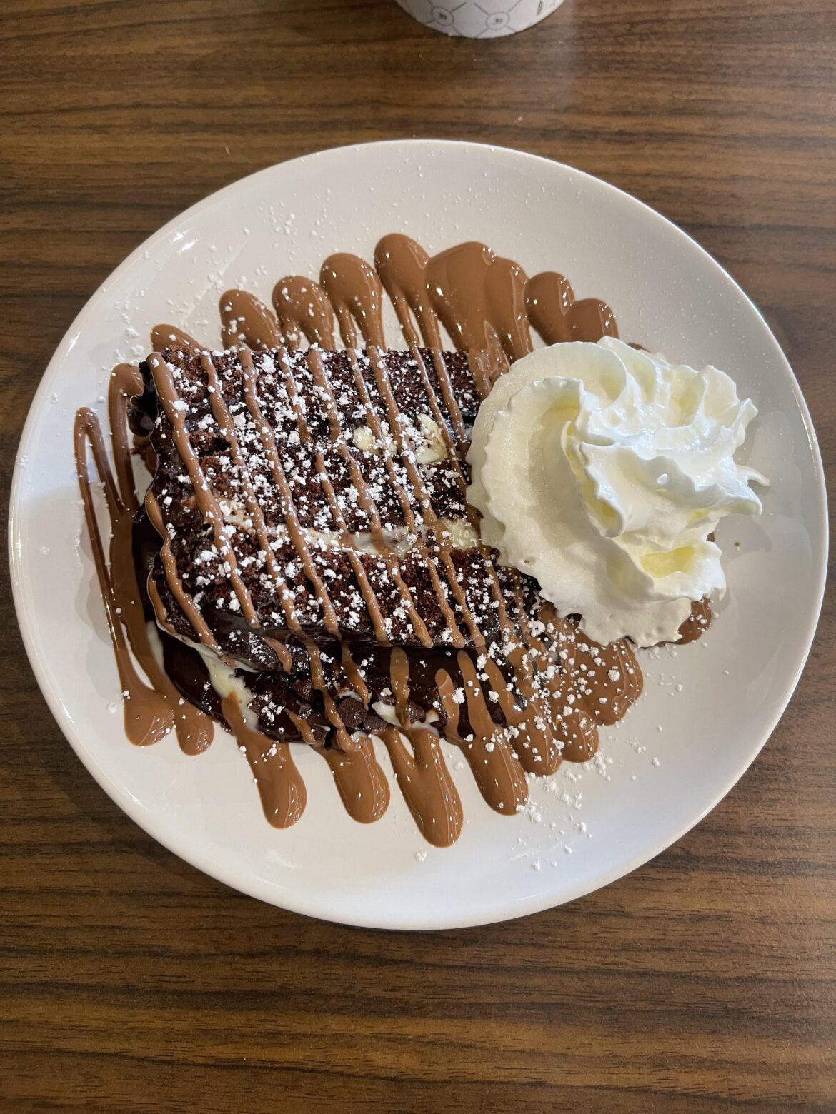 Chocolate fudge cake with chocolate drizzle and whipped cream