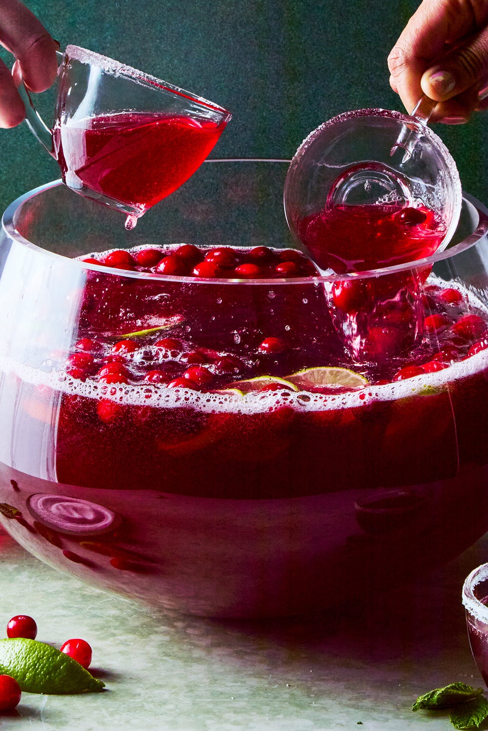 bowl of punch with cranberries and lime