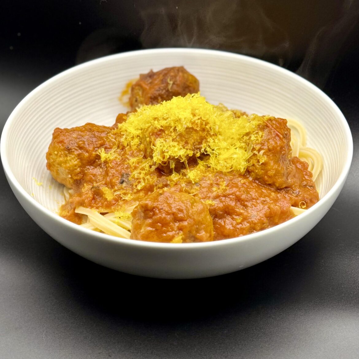 [homemade] Spaghetti triangoletti and meatballs with Calabrian chili arrabbiata, topped with a truffle cured duck egg yolk